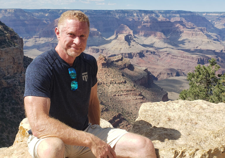 Jay Seegert sitting in front of the Grand Canyon